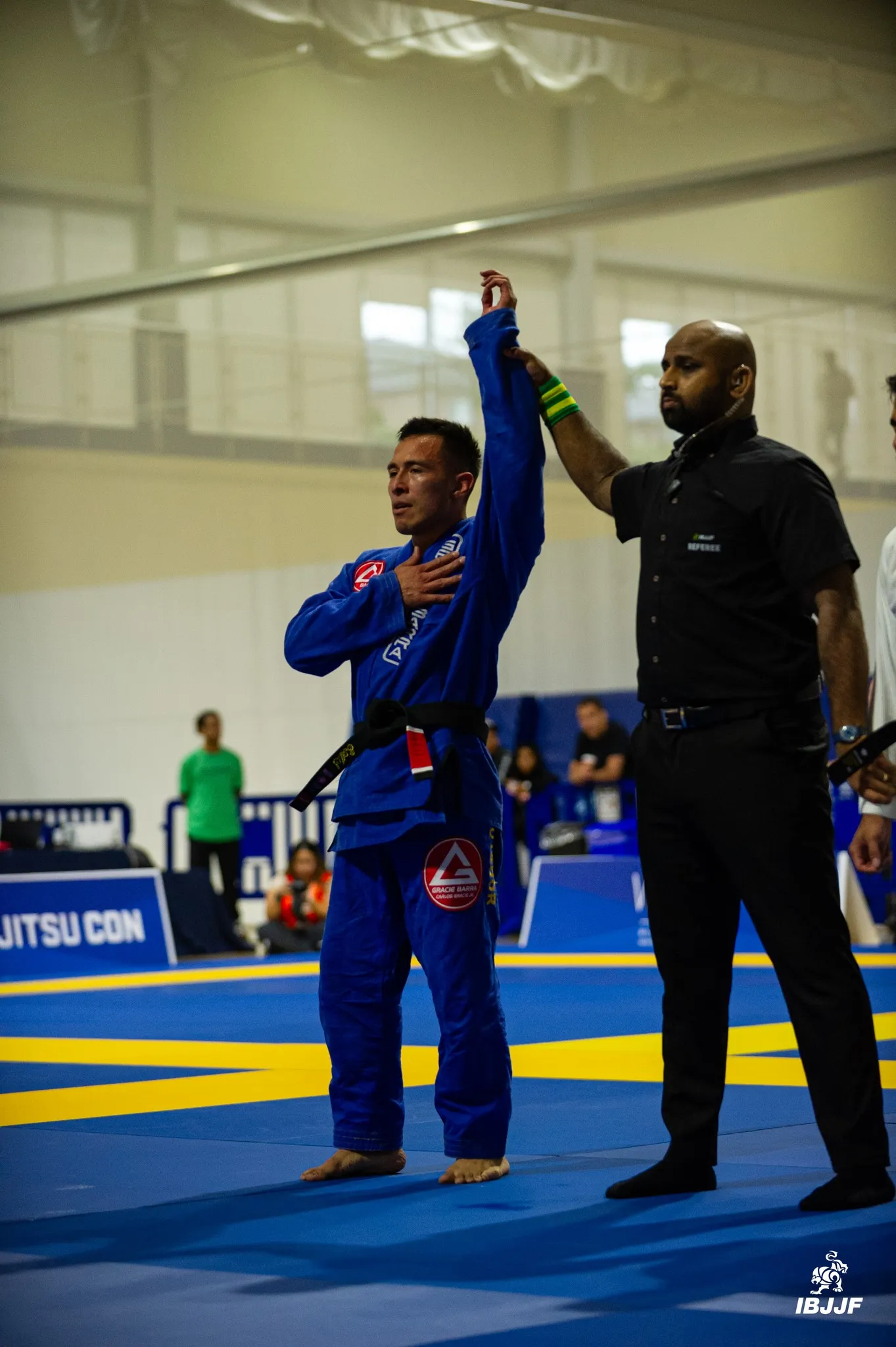 Gracie Barra athlete raising arm in competition win