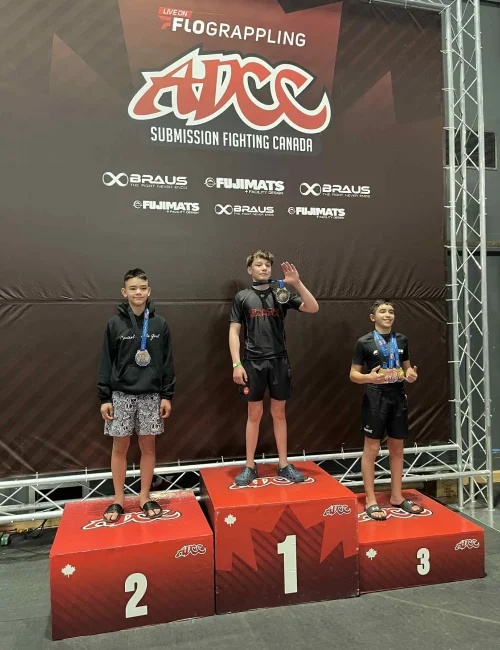 Youth athletes on ADCC podium with medals